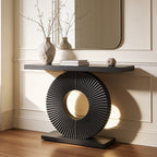 Black ribbed disc console with a dark top set against a paneled wall