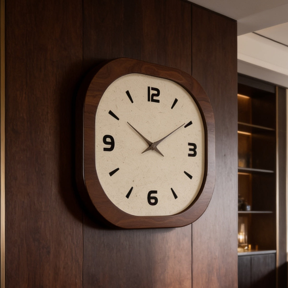 Rounded square clock with a cream dial mounted on a dark wood paneled wall