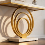 Low angle on nested gold rings supporting a white stone console top in daylight