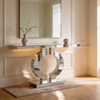 Mirrored console seen from an angle with a small vase of greenery on a soft rug