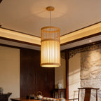 Plain slatted bamboo lantern glowing above a low tea table in a wood paneled room