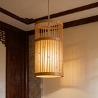 Open bamboo cage shade glowing softly in the corner of a wood paneled room