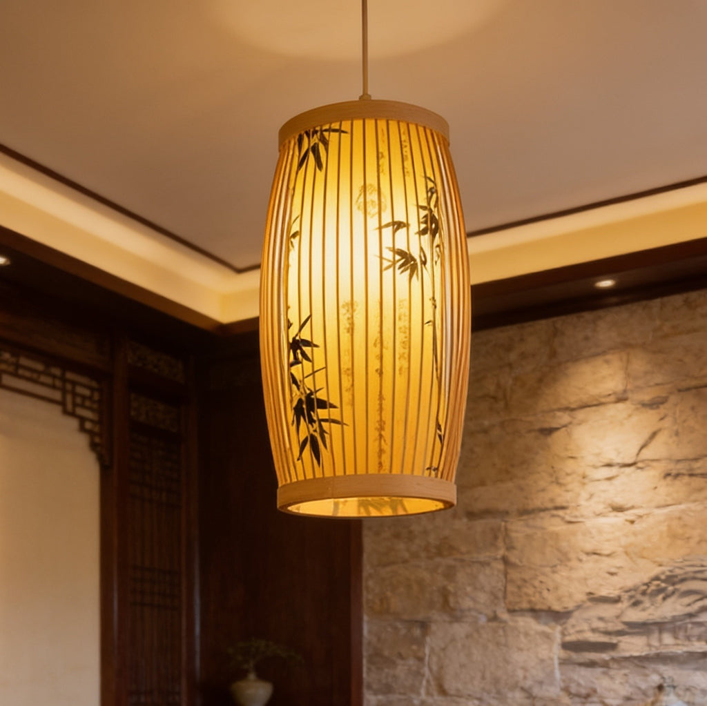 Cylinder lantern painted with bamboo stalks, lit at eye level with masonry behind