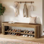 Bench under hanging coats with many pairs of shoes lined up on the shelf