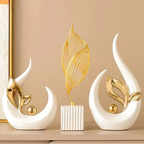 Openwork gold leaf figure and white crescent statue displayed on a peach backdrop