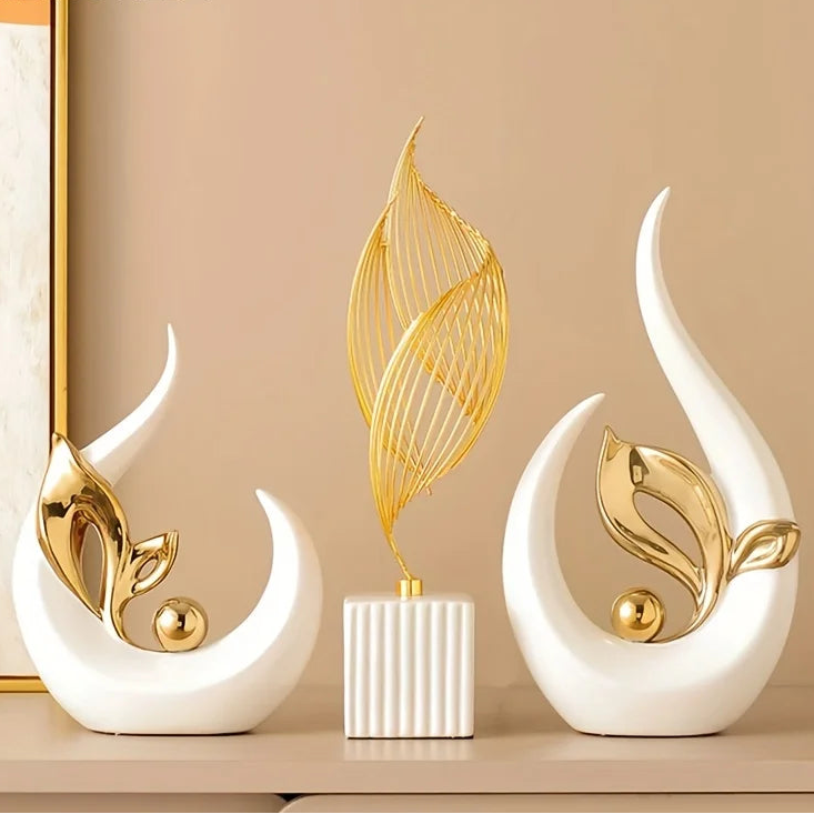 Openwork gold leaf figure and white crescent statue displayed on a peach backdrop