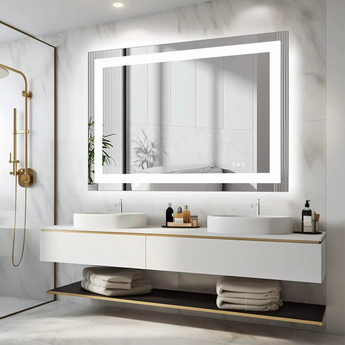 Lit frameless vanity mirror above a white floating double sink unit with gold fixtures