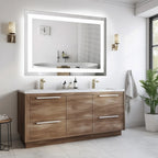 Lit mirror and warm sconces reflected above a wood vanity beside a potted plant