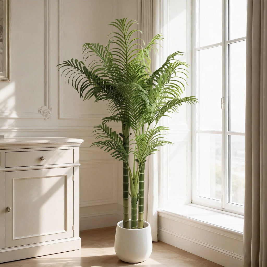 Faux areca palm in a white pot beside a tall window in a paneled living room