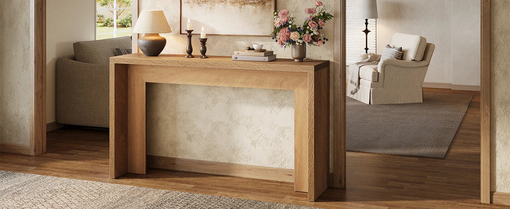 Wide view of the console behind a sofa with a lamp, candlesticks and flowers