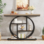 Light wood console with black rings holding books and a small clock below wall art