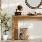 Console below a round mirror with a gramophone, tray and woven basket alongside