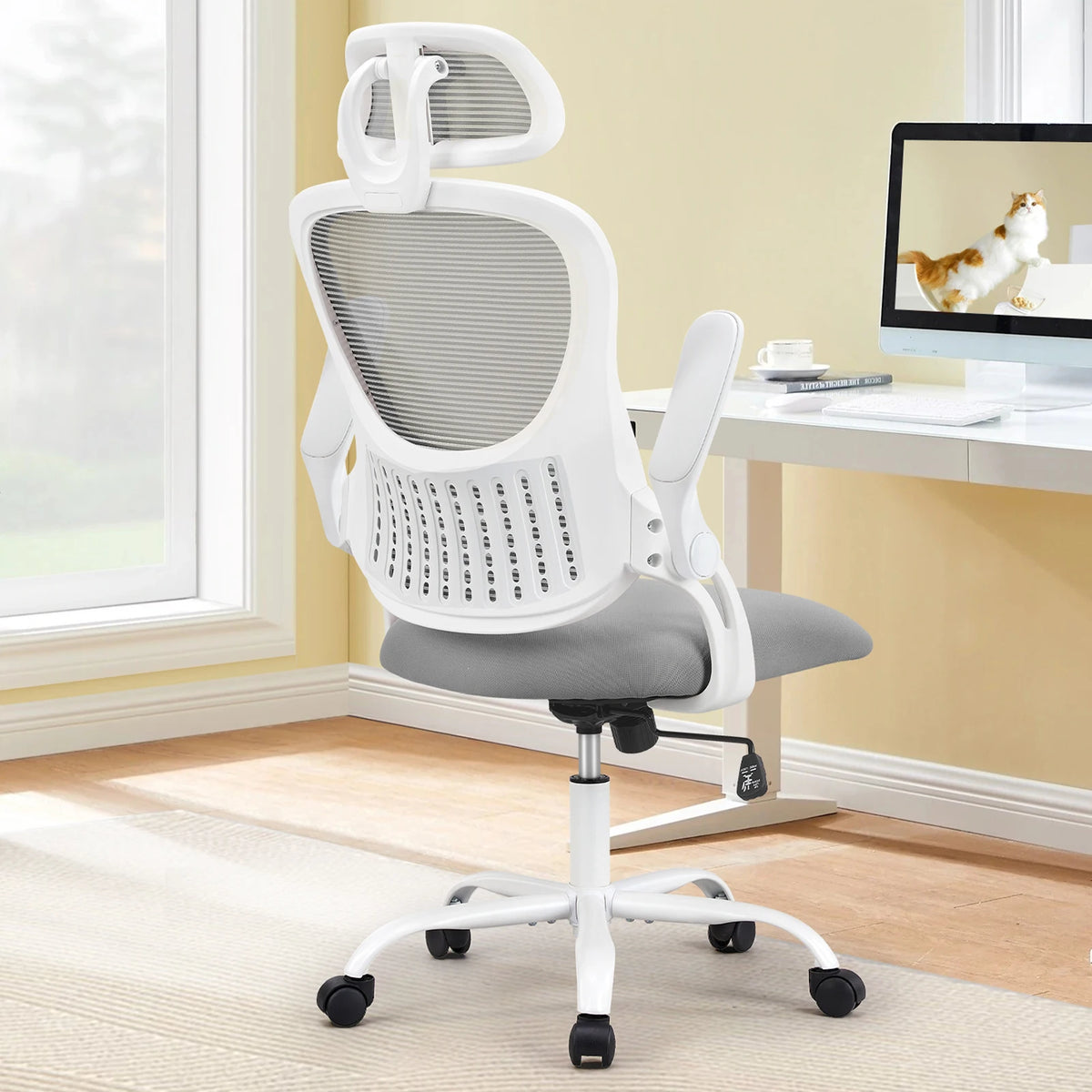 White frame chair with a gray mesh back beside a bright window and a white desk