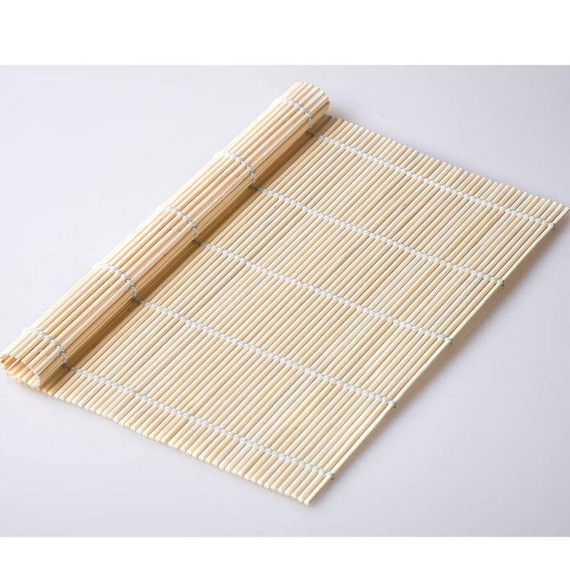 Plain bamboo rolling mat partly rolled up on a white surface