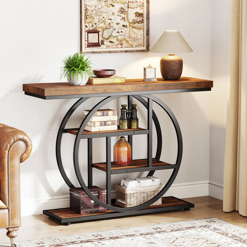 Console styled with bottles and books beside a brown leather sofa under framed art