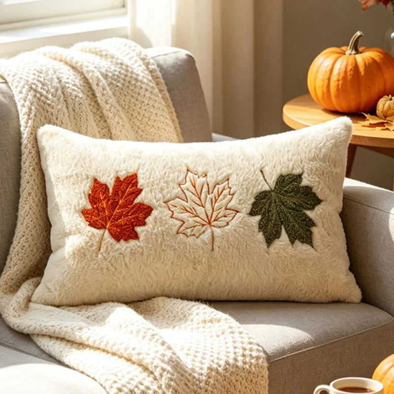 Cream lumbar pillow embroidered with red, tan and green maple leaves
