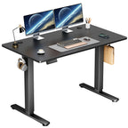 Black top electric desk with a black frame on a white background holding two screens