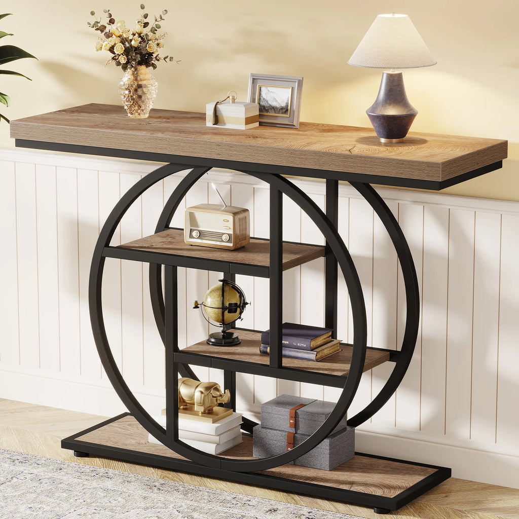Oak top console on black rings against white paneling with a lamp and framed photos