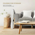 Folded saucer chair standing slim beside a sofa to show how it stores in a living room