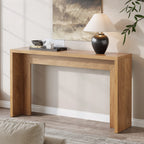 Console behind a sofa holding a lamp and bowl below framed wall art
