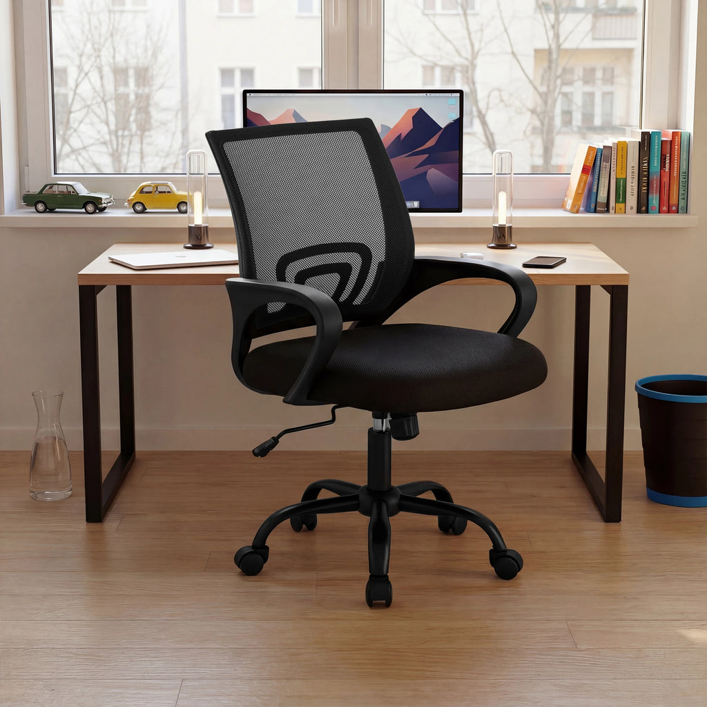 Black mesh back office chair at a desk in front of a sunlit window