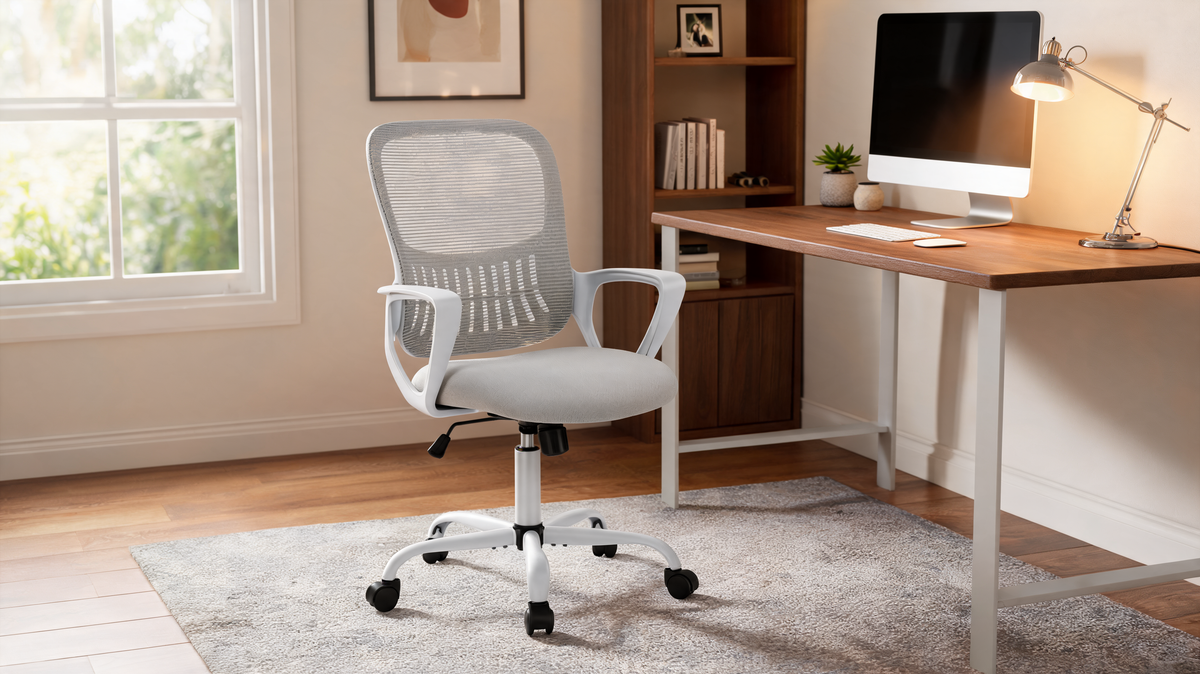 Mesh office chair with flip up armrests raised beside a desk