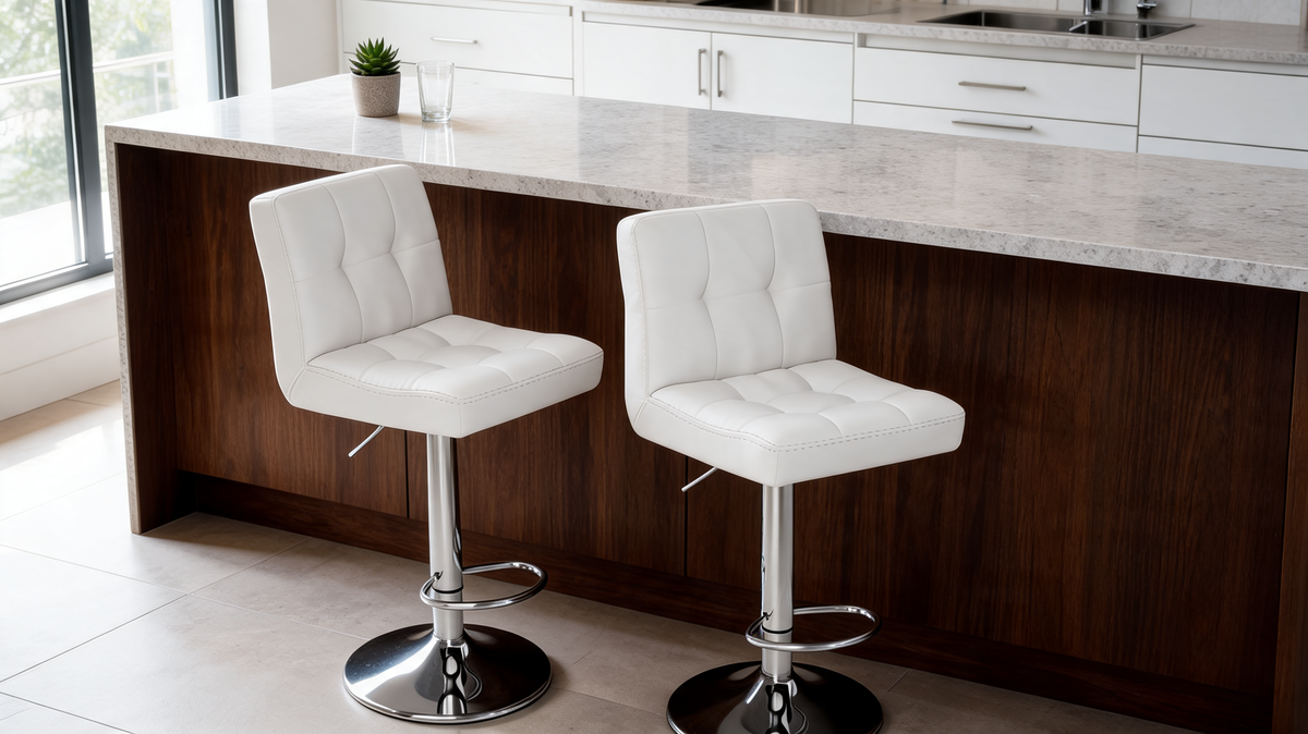 Two white PU leather bar stools at a dark wood island with a marble top