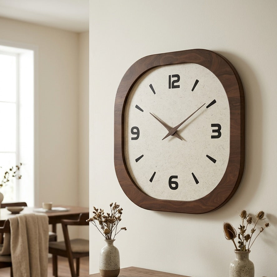Cream faced clock on a dining room wall lit by a tall window beside it
