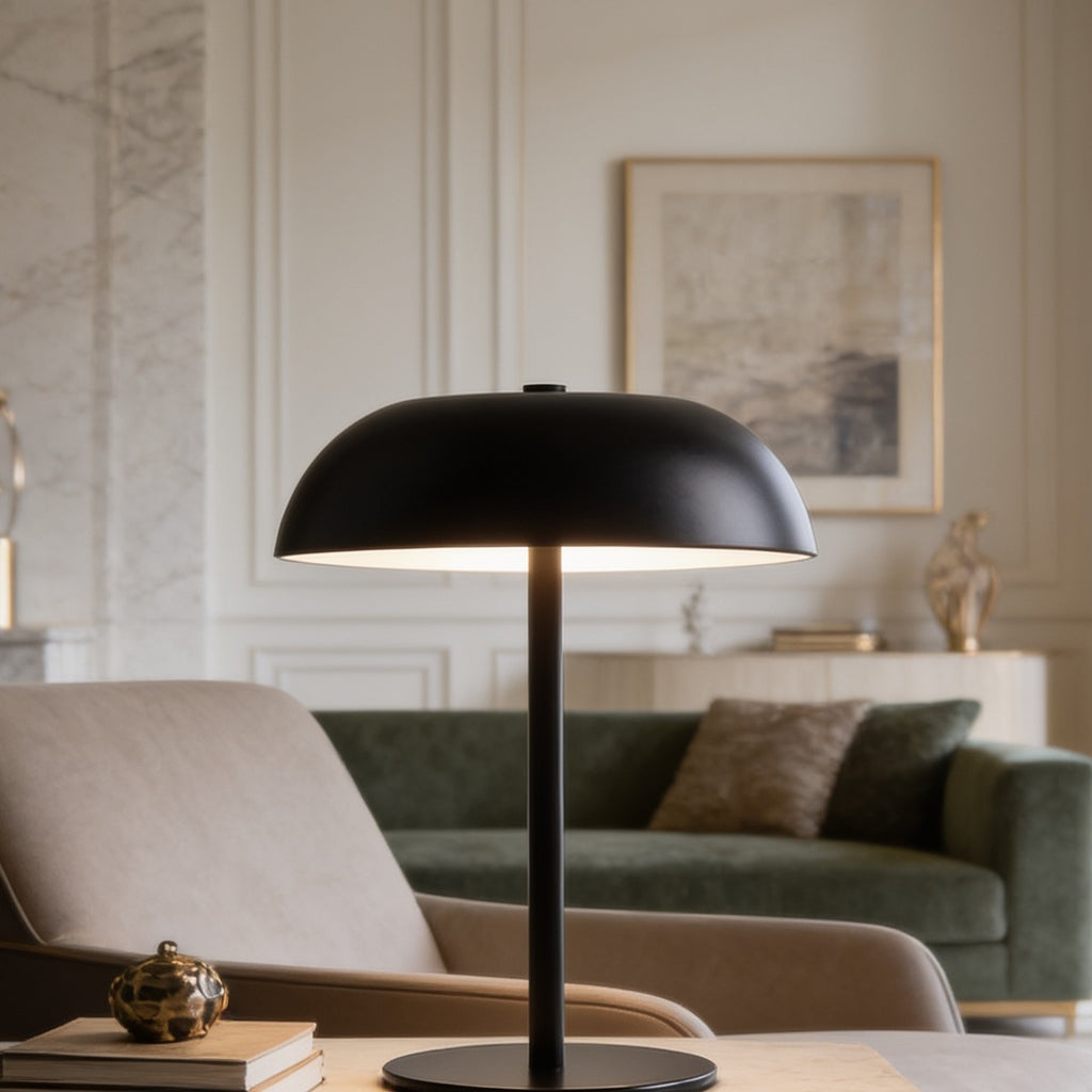 Black dome lamp standing on a side table with a green sofa in the background