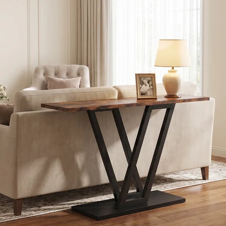 Narrow V base console standing behind a cream sofa with a lamp and framed photo