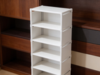 Close view of the empty white shelves showing four open tiers and the metal frame