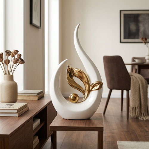 Curved white ceramic statue with gold leaf on a dark console beside dried stems