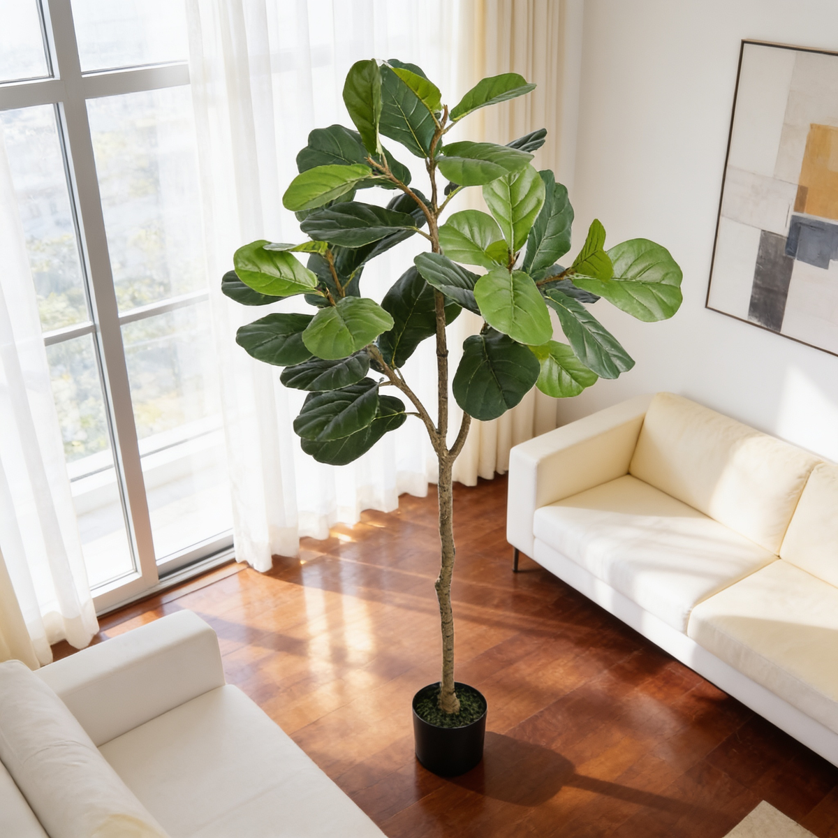 Fiddle leaf tree in a black pot by floor to ceiling windows and white seating