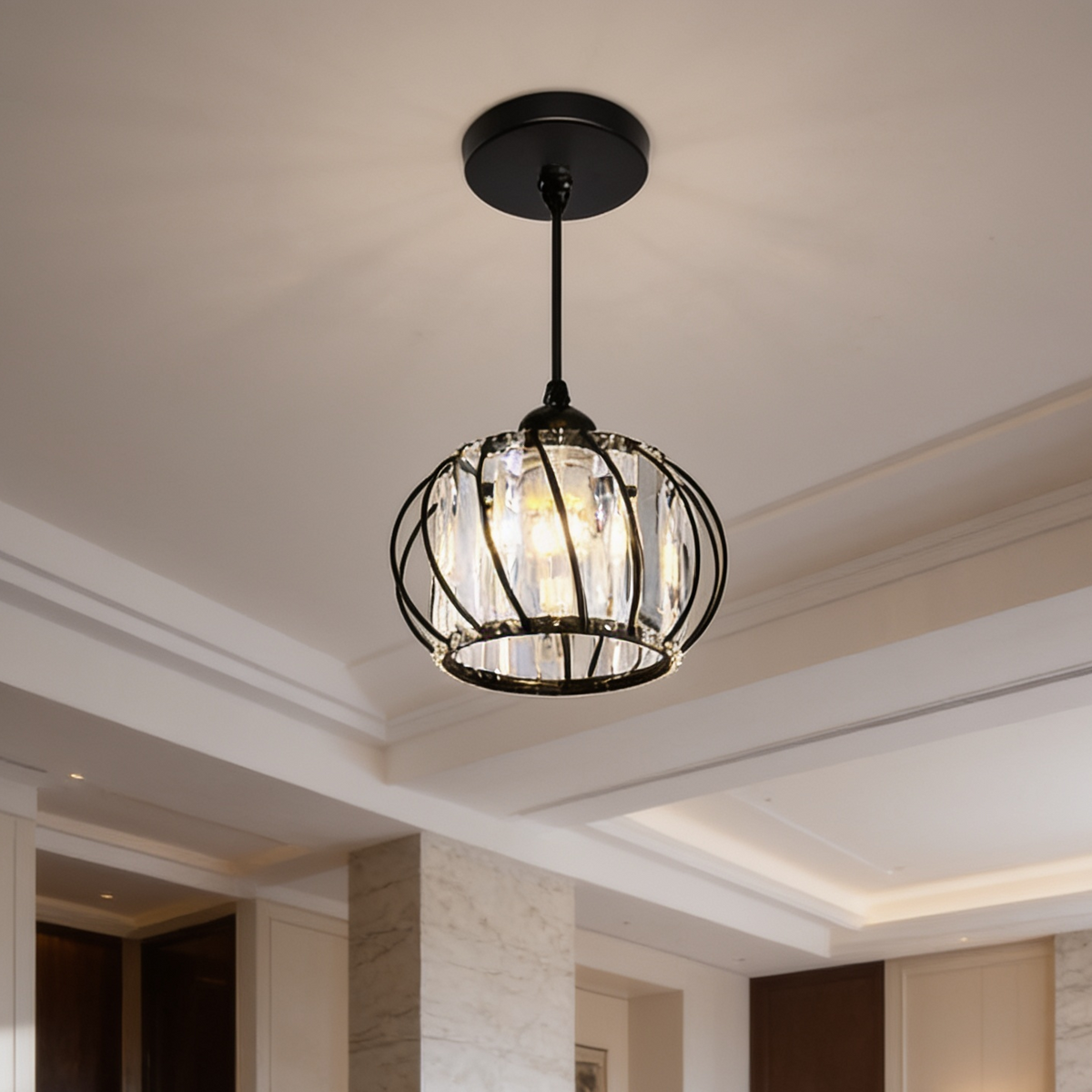 Small black cage pendant set with clear crystals lit against a white hallway ceiling