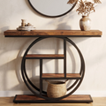 Wood console on a black ring frame in an entryway below a round mirror