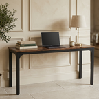 Extra long walnut desk on black legs with a laptop and lamp against paneling