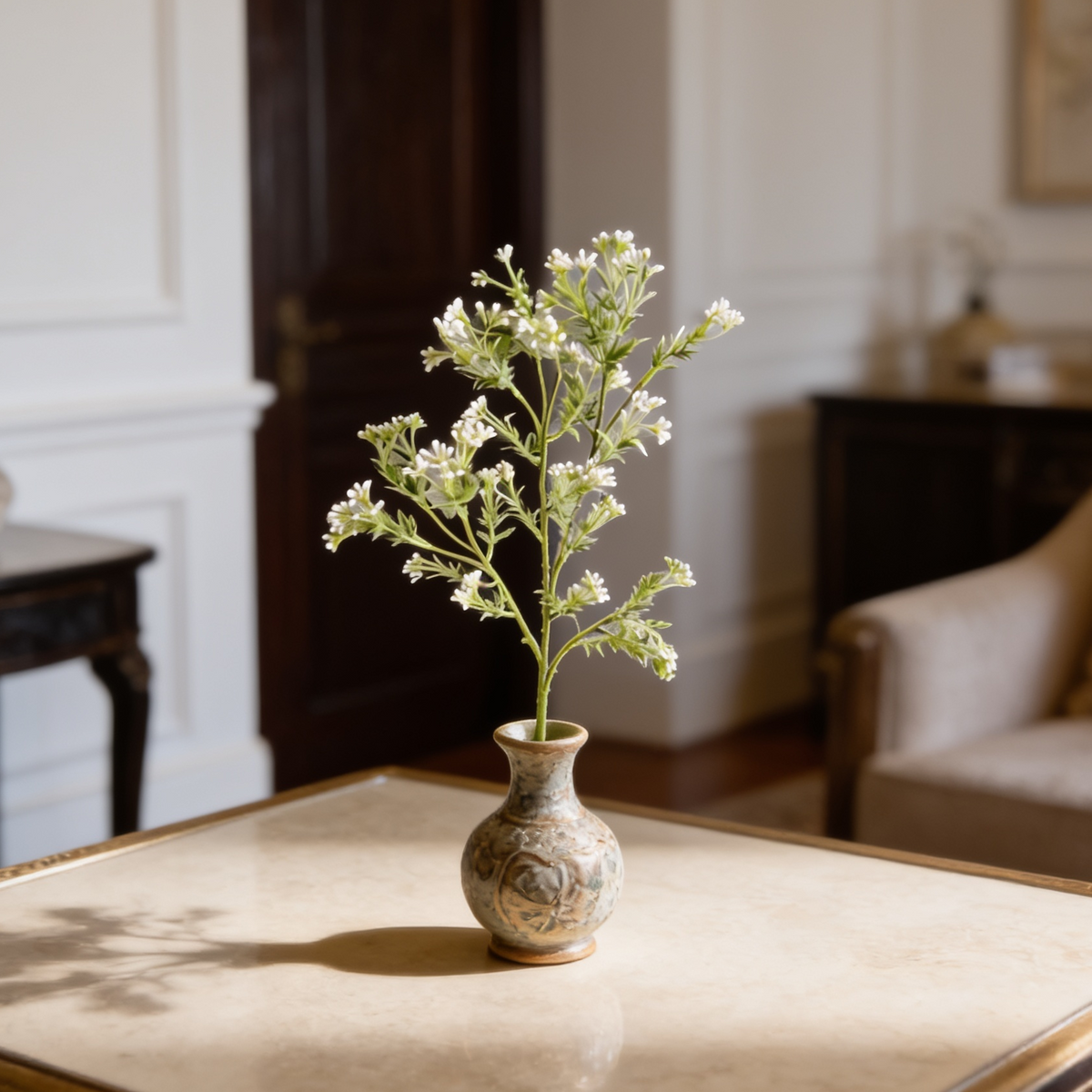 Airy white blossom branches in a stone vase on a table in a bright paneled room