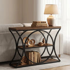 Console behind a sofa holding a lit lamp, books and a woven basket