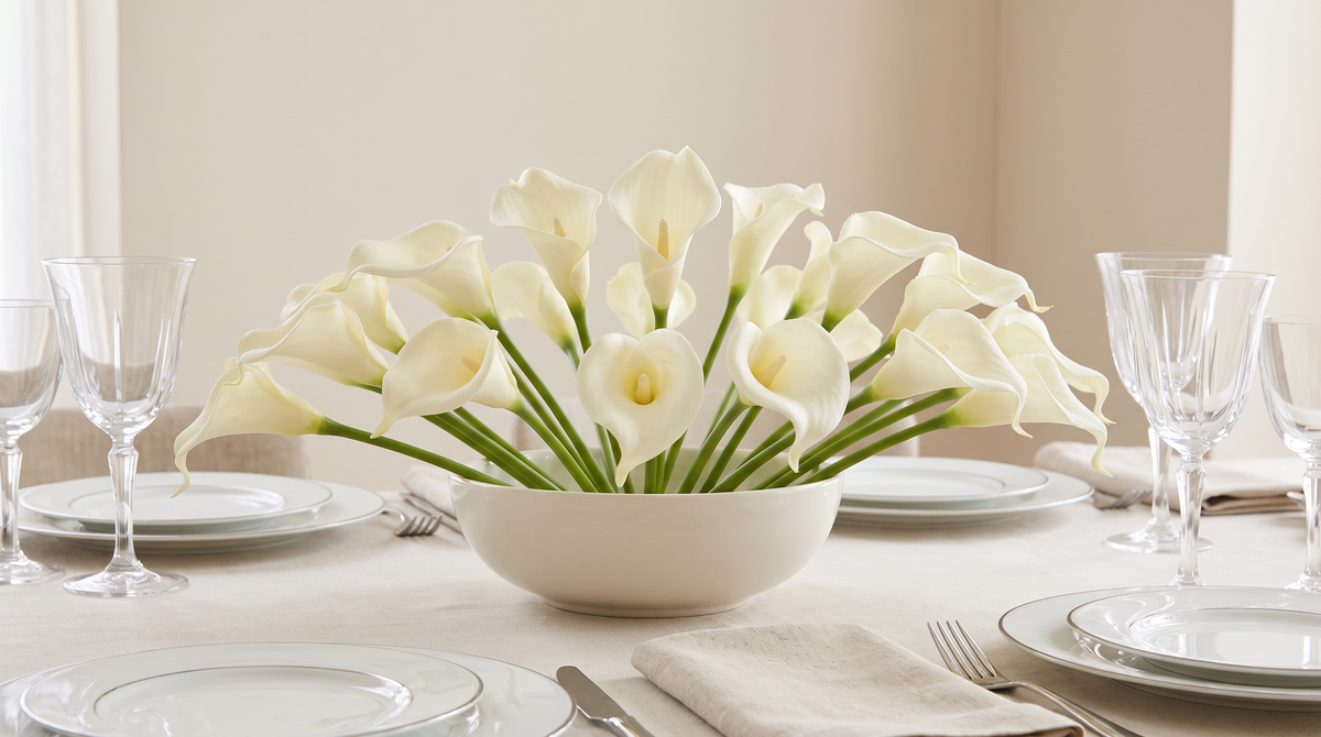 White faux calla lilies arranged in a low bowl as a table centrepiece