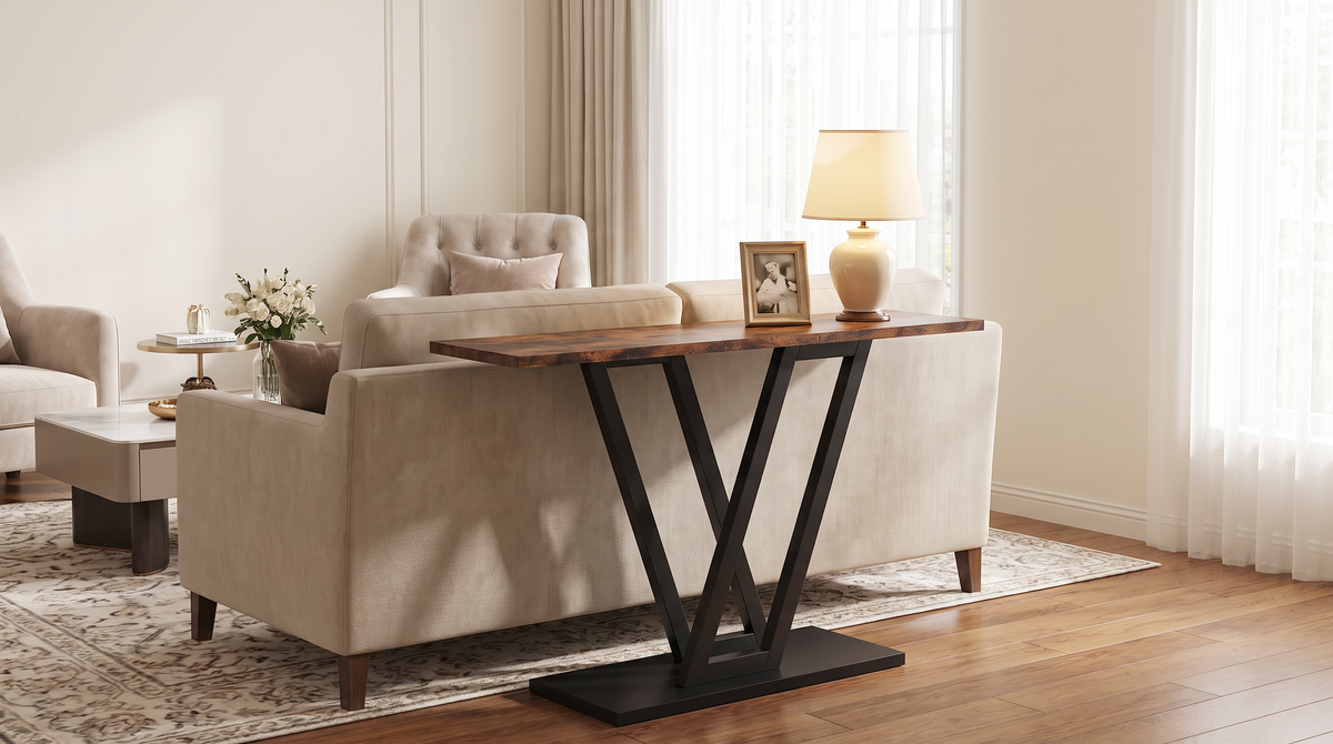 V base console table behind a sofa with a lit lamp