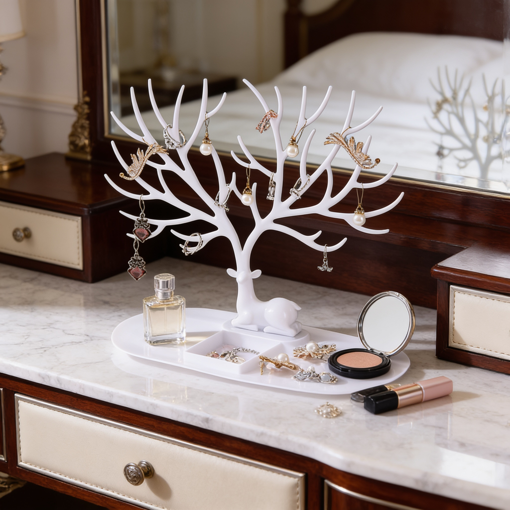 White branching jewelry tree on a vanity beside perfume bottles and a compact