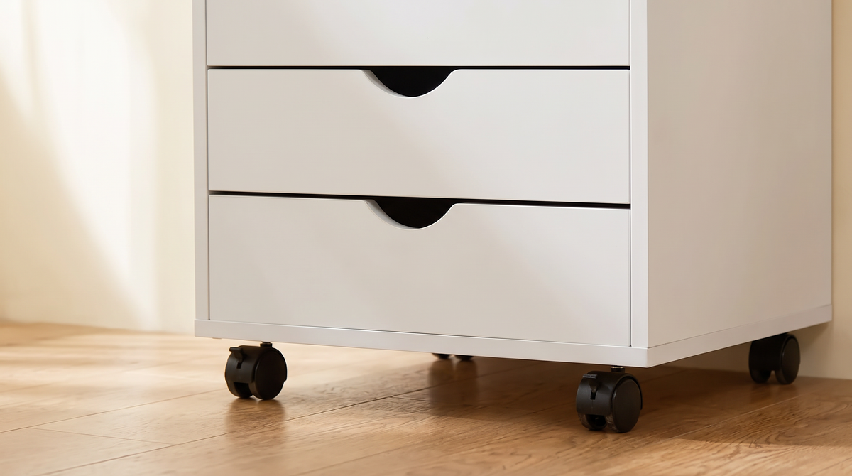 Close view of the black castors and recessed drawer pulls on the white cabinet