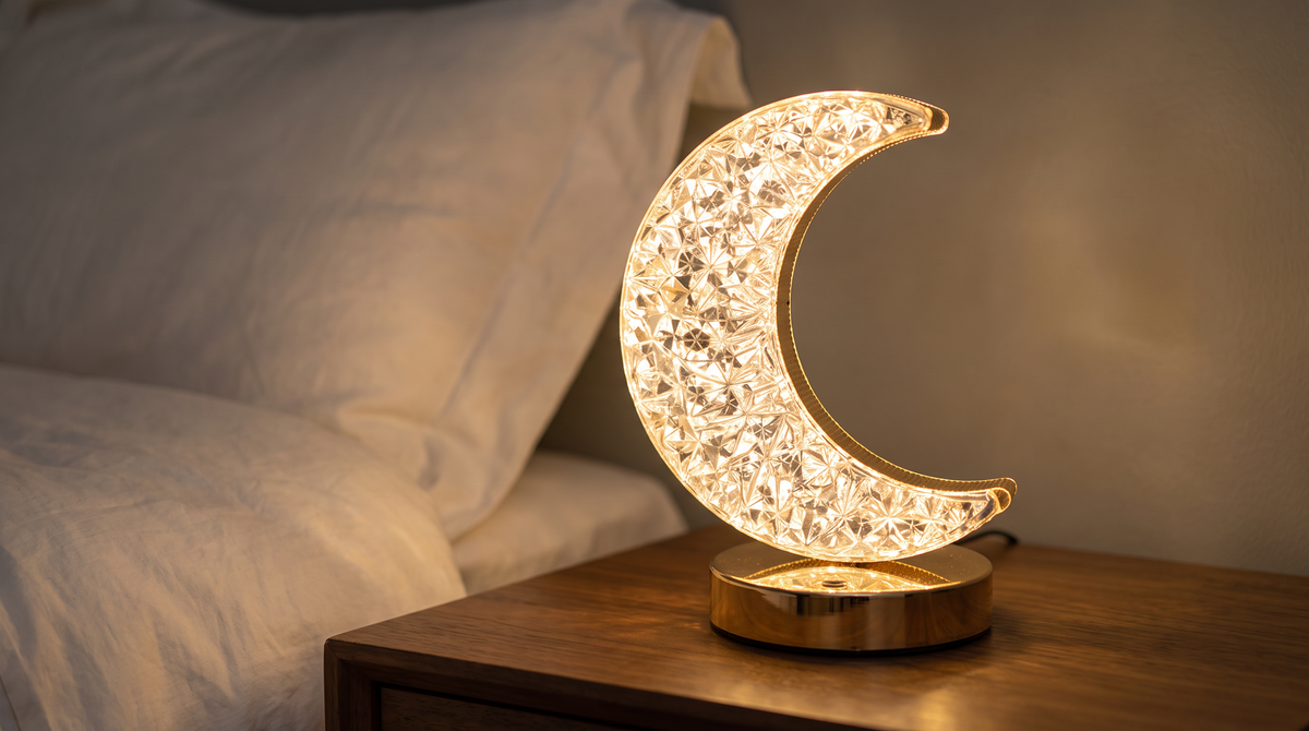 Crescent moon night light glowing on a bedside table at night