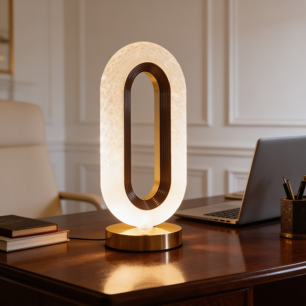 Wide desk view with the lit oval lamp beside a laptop and pen holder