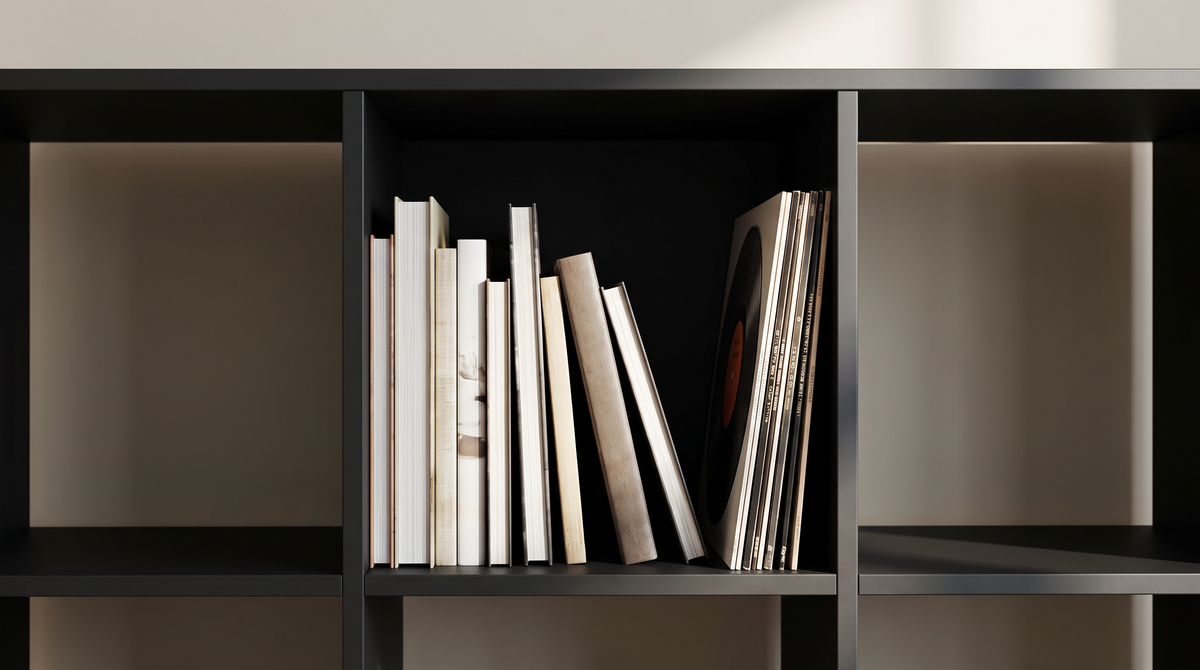 Close view of one black cube compartment holding books and a vinyl record