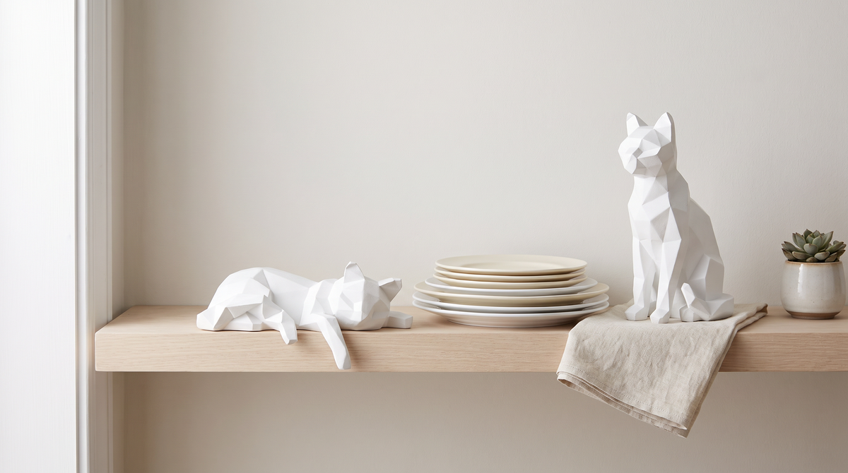White faceted cat sculpture on a pale open shelf