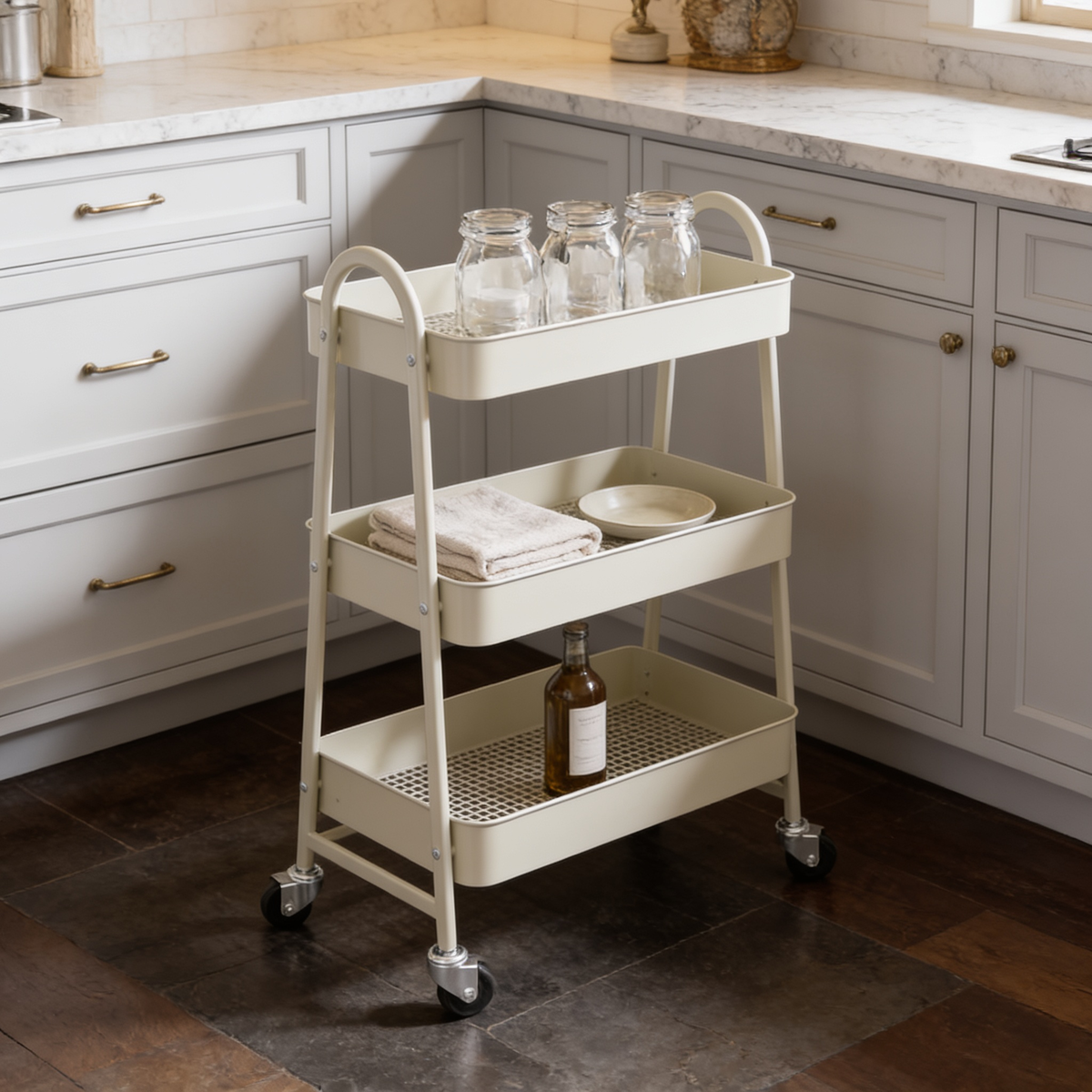 Cream three tier rolling cart in a kitchen corner holding glass jars and bottles