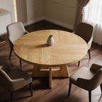 Round dining table seen from above with a small vase and chairs pulled around