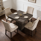 Set table with cream chairs viewed from the side near a stone wall accent
