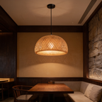 Rattan dome pendant lighting a cushioned booth and a polished wooden table